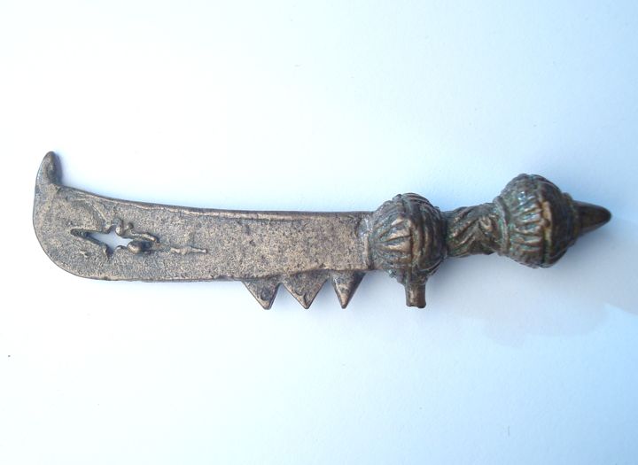 A bronze dagger with a curved blade and decorative grip, showcasing intricate designs and a pointed tip.